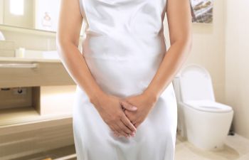 A woman in a toilet suffering from pain caused by bladder infection.