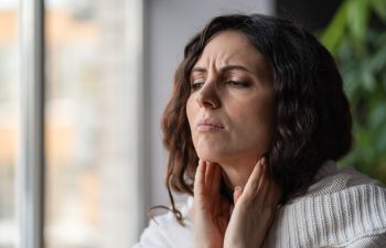 Stressed woman feeling stifness in her neck.